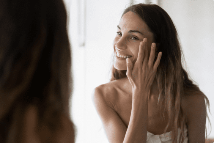 Woman Admiring Clear Skin In The Mirror